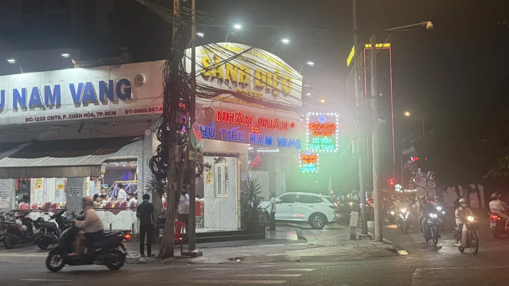 ホーチミン3区CMT8通り沿いにあるフーティウ専門店Nhân Quán Sài Gònのネオン看板と夜の店構え