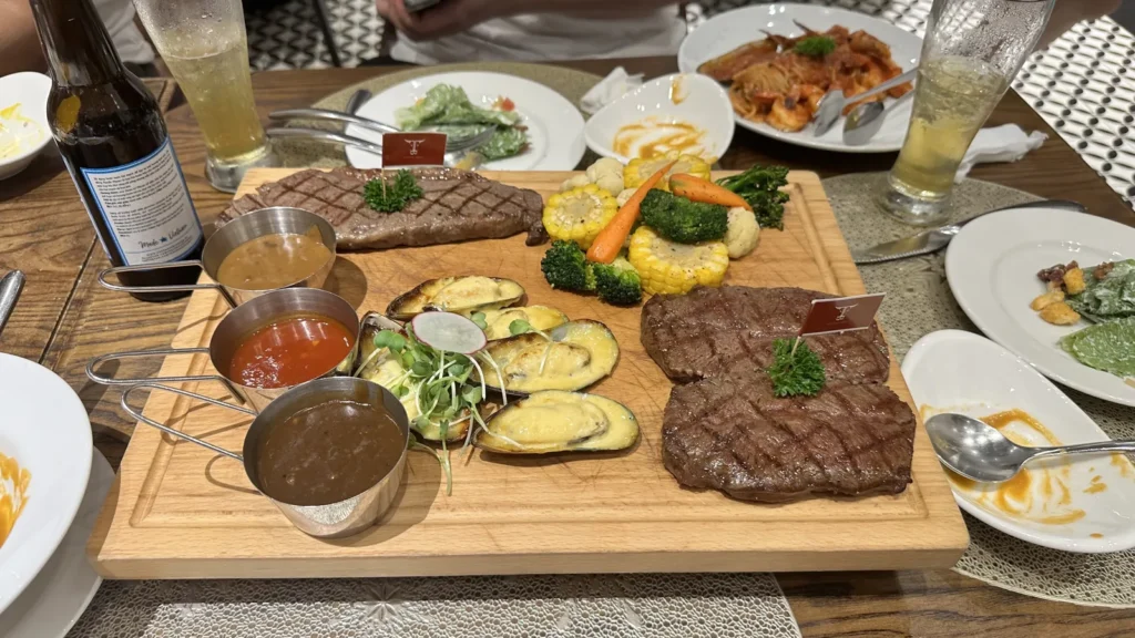 Steak Love The Villaのステーキボード。2種類のステーキ、ムール貝のチーズ焼き、グリル野菜と3種類のソース
